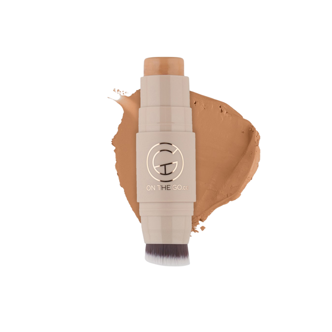 Makeup stick with a swatch of brown color on a white background